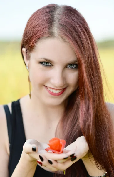 Mujer sosteniendo una flor de amapola — Foto de Stock