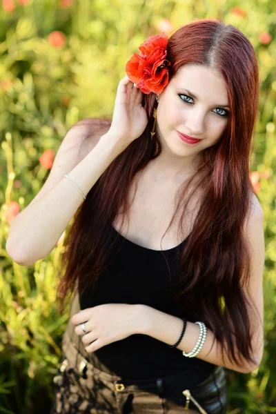 Mujer sosteniendo una flor de amapola — Foto de Stock