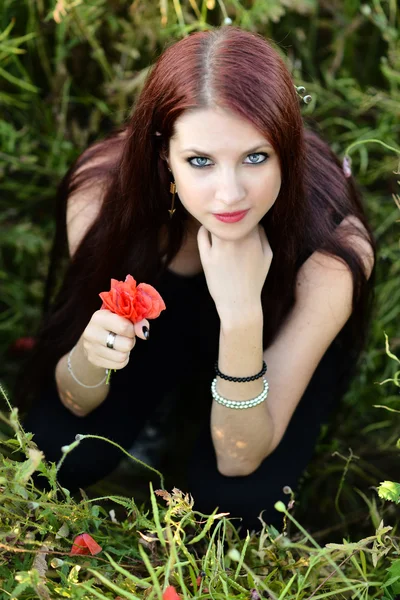 Vrouw met een klaproos bloem — Stockfoto