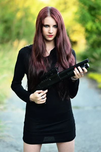 Sexig kvinna med vapen i hand — Stockfoto