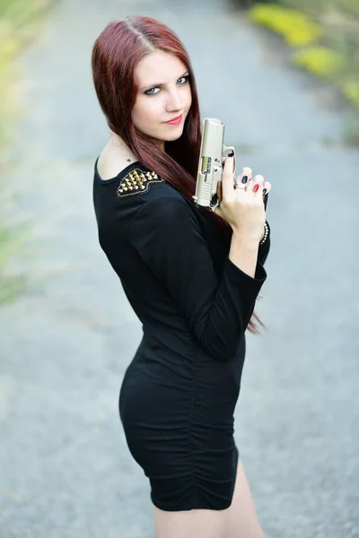 Sexy mujer sosteniendo pistola en la mano — Foto de Stock