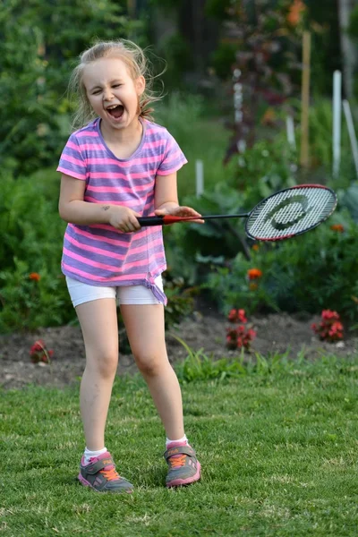 Schattig klein meisje spelen badminton — Stockfoto