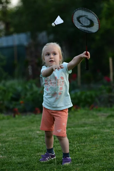 Милая маленькая девочка играет в бадминтон — стоковое фото