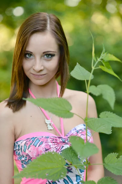 Woman gathers nettle at spring garden — Stock Photo, Image