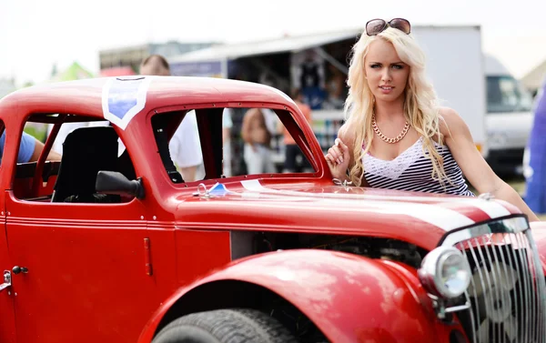 Blonde vrouw in de buurt van sport auto — Stockfoto