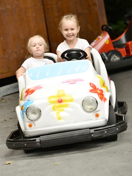 Two girls riding toy car — Stock Photo, Image