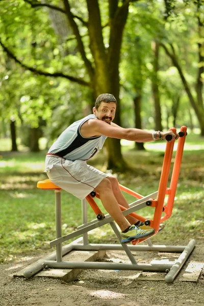 Treino de homem em uma máquina de fitness — Fotografia de Stock