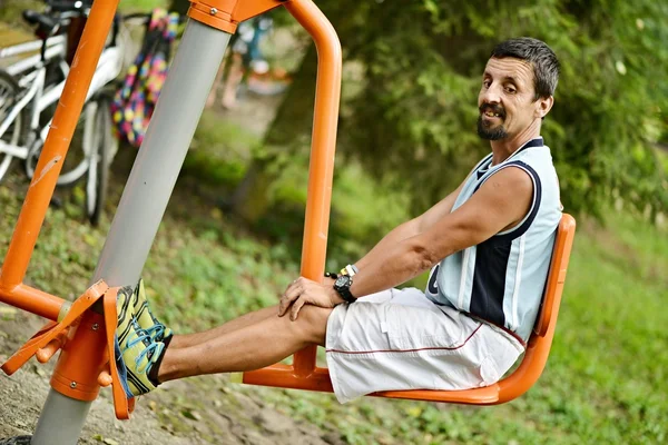 Treino de homem em uma máquina de fitness — Fotografia de Stock