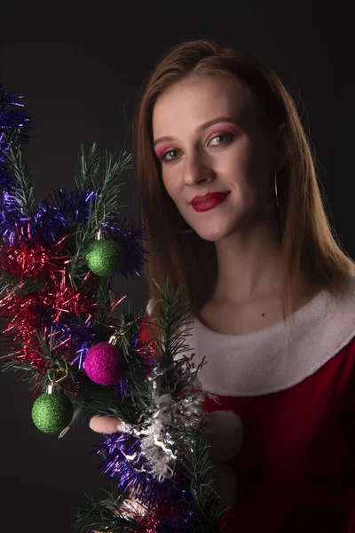 Vidám Lány Piros Karácsonyi Mikulás Jelmez Pózol Díszített Karácsonyfa Stúdióban — Stock Fotó