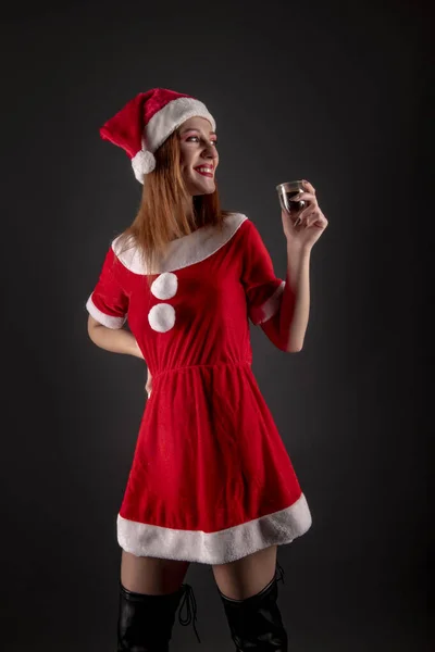 Весела Дівчина Червоному Різдвяному Костюмі Санти Випивкою Позує Студії — стокове фото