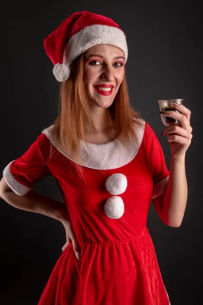 Fröhliches Mädchen Roten Weihnachtsmann Kostüm Mit Getränk Posiert Studio — Stockfoto