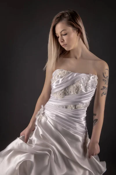 セクシーな花嫁バックウェディングドレス 女は白いガウンを脱ぐ 黒を背景にした女性を見る ブライダルファッション — ストック写真