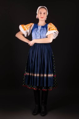 Geleneksel elbiseli, siyah arka planda poz veren güzel, Slovak bir kadın. Slovakça folklor