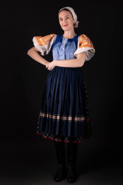 Geleneksel elbiseli, siyah arka planda poz veren güzel, Slovak bir kadın. Slovakça folklor