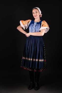 Geleneksel elbiseli, siyah arka planda poz veren güzel, Slovak bir kadın. Slovakça folklor