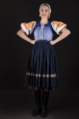 Geleneksel elbiseli, siyah arka planda poz veren güzel, Slovak bir kadın. Slovakça folklor