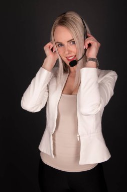 Merkezi ara. Gülümseyen kadın telefon operatörü, kulaklıklı, gri takım elbiseli, gri arka planda izole edilmiş.. 