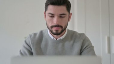 Dizüstü bilgisayar kullanırken Genç Adam 'ın Kafasını Evet olarak Sallayan Portresi