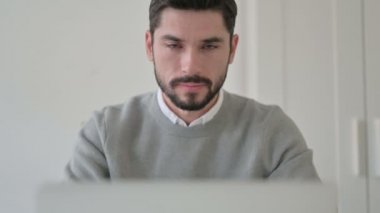 Dizüstü bilgisayar kullanırken Başparmakları Gösteren Genç Adam Portresi