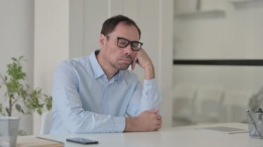 Uykulu Orta yaşlı adam ofiste otururken kestiriyor.
