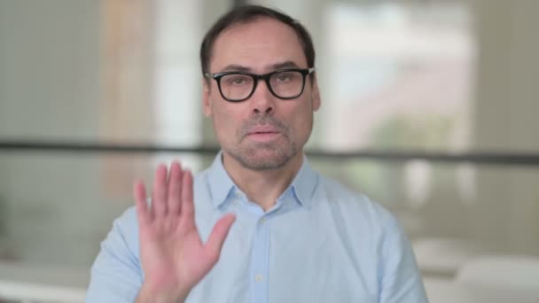 Среднего возраста мужчина показывает стоп знак от руки — стоковое видео