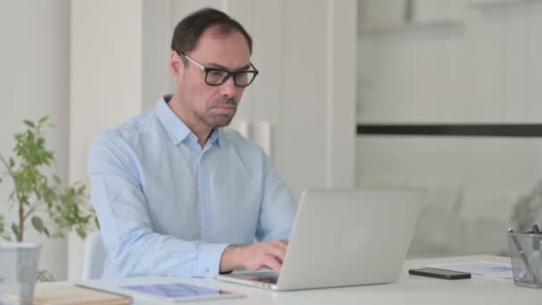 Középkorú férfi laptoppal mutató hüvelykujj lefelé jel — Stock videók