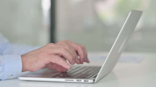 Primer plano del hombre de mediana edad escribiendo en el ordenador portátil — Vídeo de stock