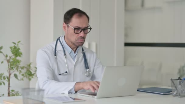 Medico di mezza età che lavora sul computer portatile in ufficio — Video Stock