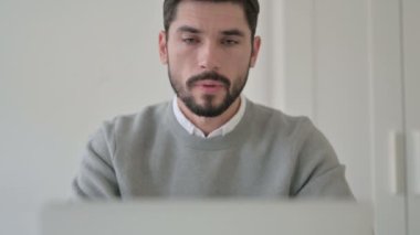 Dizüstü bilgisayarda çalışan genç adamın portresi