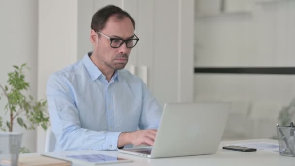 Mężczyzna w średnim wieku z Laptop potrząsający głową jak tak znak — Wideo stockowe
