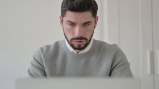 Porträt eines jungen Mannes, der beim Benutzen eines Laptops hustet — Stockvideo