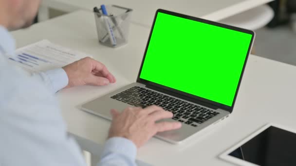 中年人使用带有绿色彩色屏风的笔记本电脑 — 图库视频影像