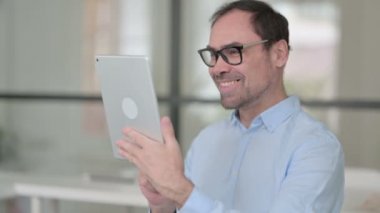 Ofisteki Orta Yaşlı Adam 'ın Tablet' teki Görüntü Çağrısı 