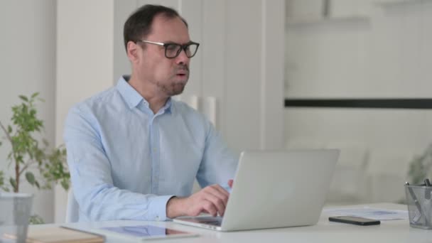 Homem de meia-idade tosse ao usar laptop no escritório — Vídeo de Stock