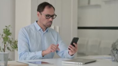 Ofiste Orta Yaşlı Adam Akıllı Telefonla Konuşuyor 