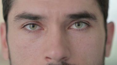 Genç adamın yanıp sönen gözleri kameraya bakıyor.