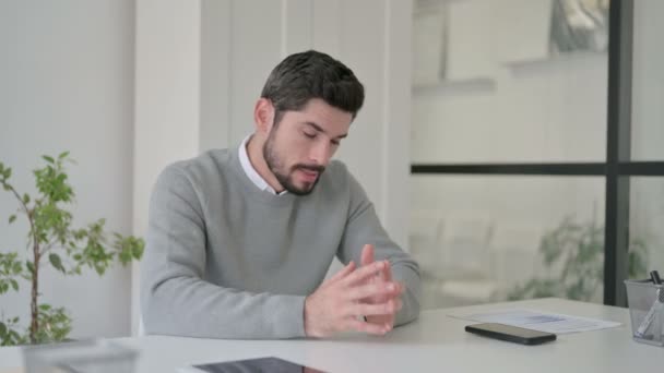 Zdenerwowany młody człowiek czuje się zaniepokojony siedząc w biurze — Wideo stockowe