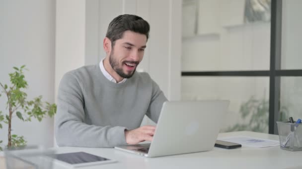 Jongeman in gesprek op video op Laptop in Office — Stockvideo