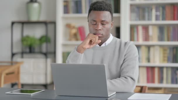図書館でノートパソコンを使いながら考えるアフリカ人男性 — ストック動画