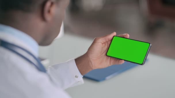 Rear View of African Doctor Holding Smartphone with Green Chroma Key Screen — Stock Video