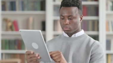 Kütüphanede Tablet kullanan Çekici Afrikalı Adam Portresi 