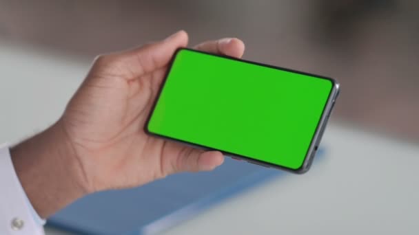 Человек, держащий смартфон с экраном Green Chroma Key — стоковое видео