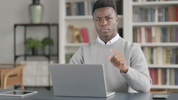 図書館でノートパソコンを使用している間、アフリカの男は兆候として頭を振る — ストック動画