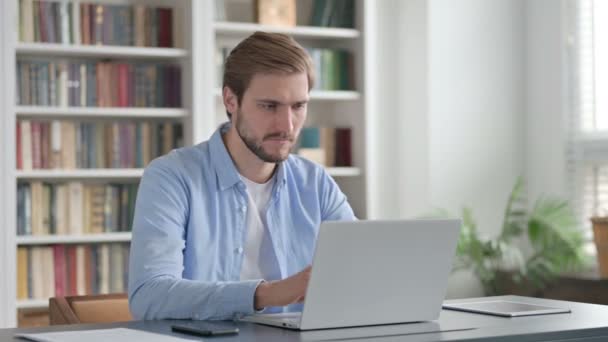 Hombre sacudiendo la cabeza como ninguna señal mientras usa el ordenador portátil — Vídeo de stock