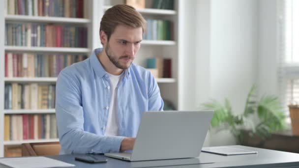 Hombre trabajando en el ordenador portátil en la oficina — Vídeo de stock