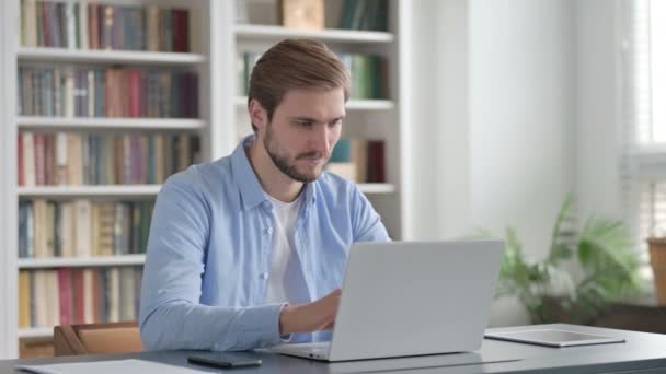 Mann zeigt bei der Arbeit mit Laptop Daumen hoch — Stockvideo