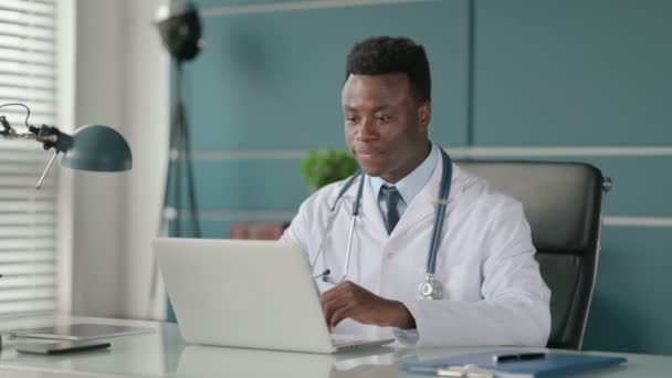 Африканский врач говорит на видео-звонок на ноутбуке в офисе — стоковое видео