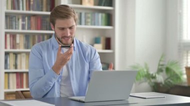 Adam dizüstü bilgisayar kullanırken telefonda kızgın hissediyor 