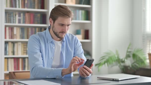 Framgångsrik man firar på smartphone — Stockvideo