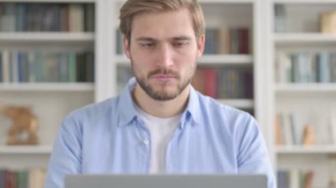 Dizüstü bilgisayar kullanırken başağrısı olan bir adamın portresi